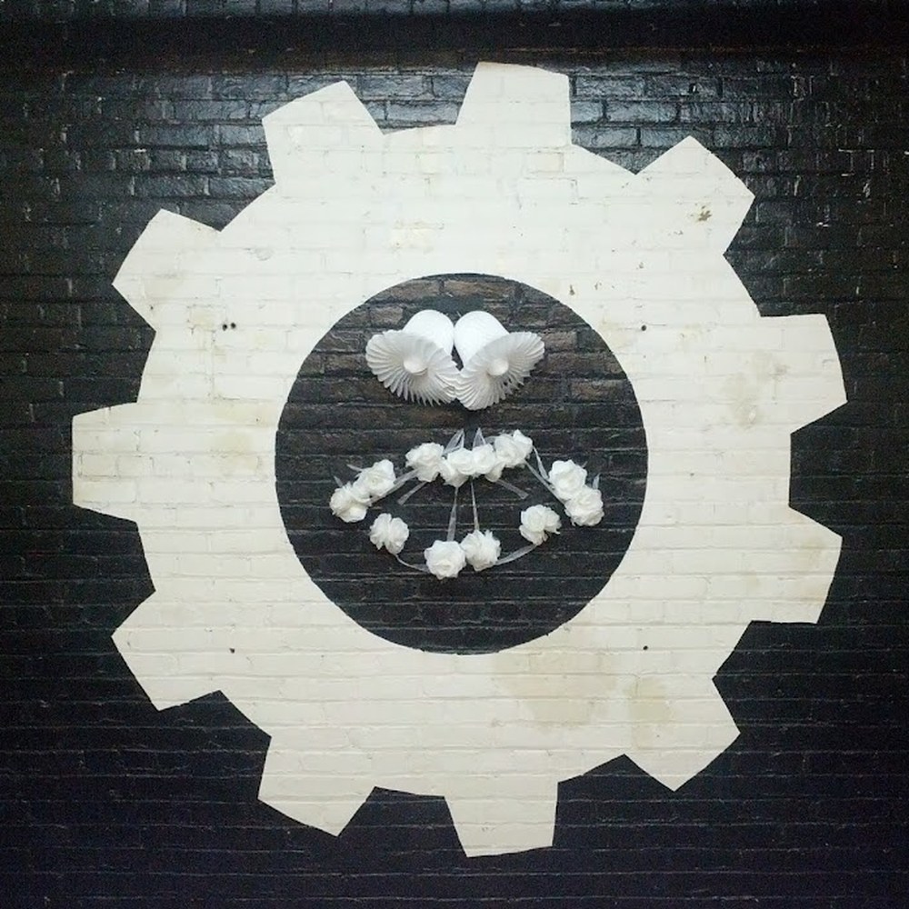 The Interlock Rochester gear logo painted on a brick wall